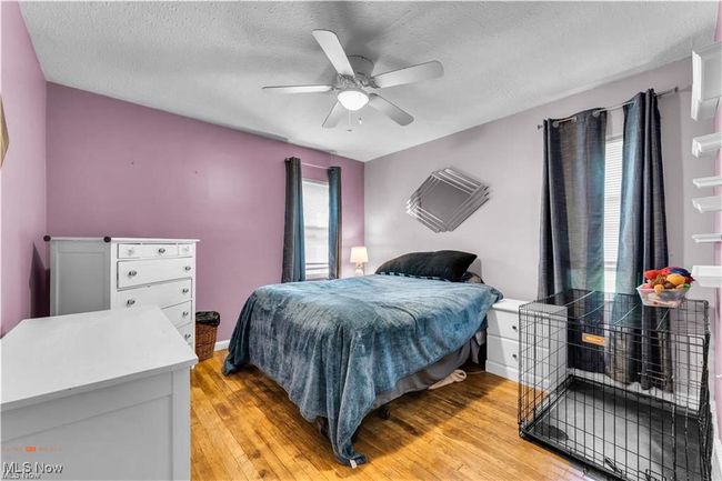 Bedroom with light wood-type flooring, a textured ceiling, ceiling fan, and baseboards | Image 17