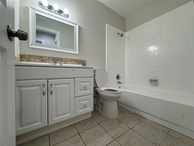 Bathroom with toilet, vanity, and tub / shower combination | Image 19