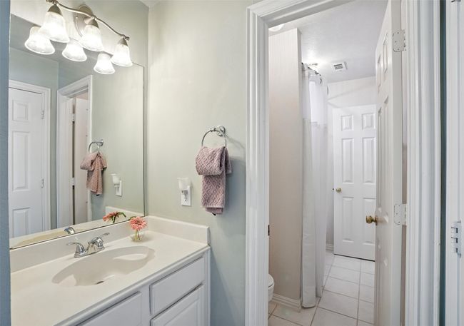 Bathroom with tile patterned floors, vanity, a chandelier, and a shower with curtain | Image 29