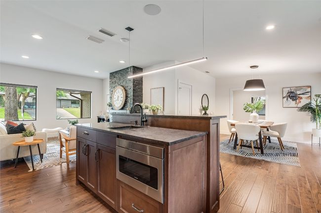 The kitchen opens seamlessly to the spacious dining area and living room and comes lined with windows over the sink so you can enjoy peaceful tree-filled views. | Image 20