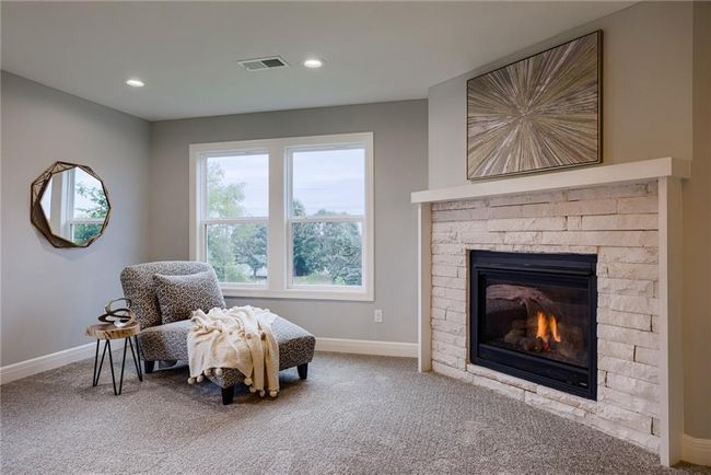 Sitting room with a stone fireplace and carpet floors | Image 28