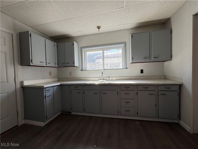 Kitchen featuring dark wood-type flooring, a sink, and gray cabinetry | Image 19
