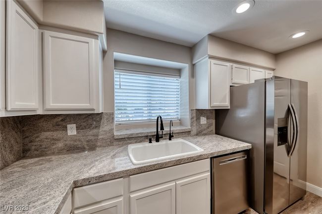 Kitchen with appliances with stainless steel finishes, white cabinetry, backsplash, light countertops, and recessed lighting | Image 13