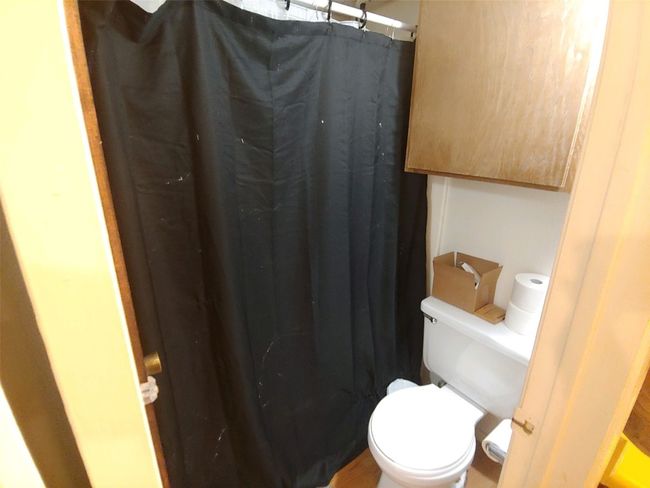 Bathroom with toilet and a shower with curtain | Image 11