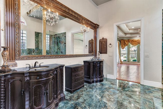 Double vanities make getting ready for work or an evening out so easy! Don't forget to appreciate all the royal touches such the crystal light fixtures and chandelier, plus the thick carved molding around the mirror. | Image 25