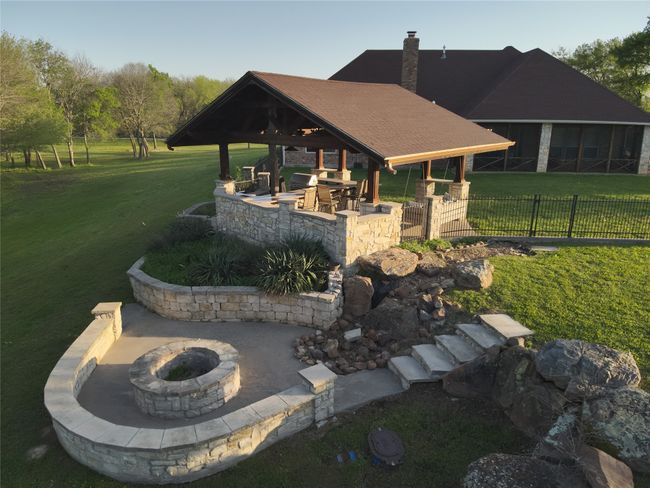 View of property's community featuring an outdoor fire pit, a patio, a yard, and fence | Image 26