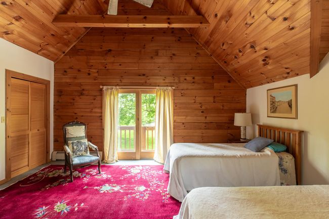 Carpeted bedroom featuring wooden ceiling, access to exterior, and wooden walls | Image 22