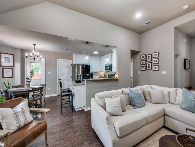 Living room with dark wood-style flooring, a chandelier, recessed lighting, baseboards, and vaulted ceiling | Image 7