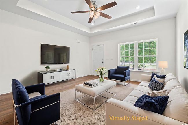 Living area with a tray ceiling, wood finished floors, a ceiling fan, and recessed lighting | Image 5