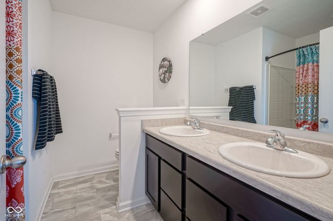 bathroom with double vanity and curtained shower | Image 22