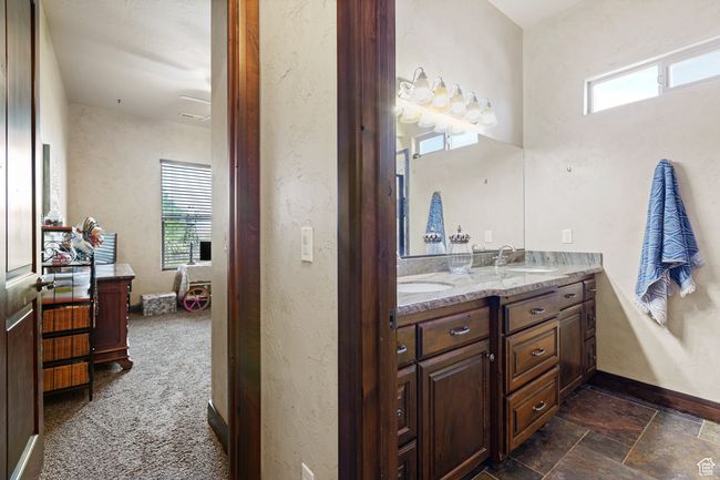 Full bath with double vanity, plenty of natural light, and stone finish floors | Image 15