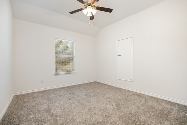 Spare room featuring carpet flooring, vaulted ceiling, baseboards, and a ceiling fan | Image 22