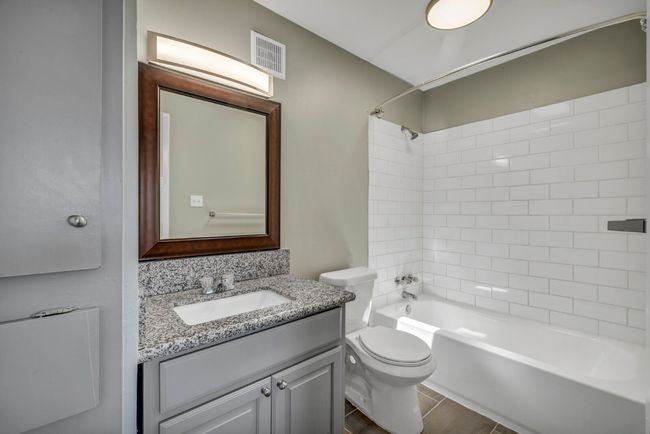 Bathroom featuring toilet, vanity, shower / tub combination, and tile patterned floors | Image 12