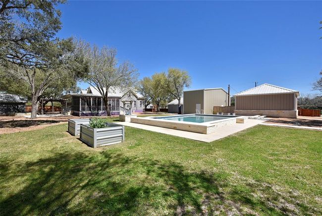 This view of the pool shows the raised planter beds. Behind the pool to the right is a oversized garage for the Guest house. In the middle is the RV garage and the the left of the RV garage is the craft house/workshop. The craft shop/workshop has its own central A/C unit. | Image 24
