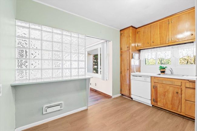 Kitchen with dishwasher, ornamental molding, sink, and light hardwood / wood-style floors | Image 8