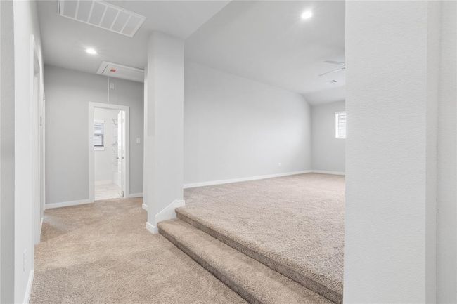 The second floor game room is elevated and is very spacious. Here is a view of the second floor looking at the game room, a secondary bathroom, and hallway leading to secondary bedrooms. | Image 14