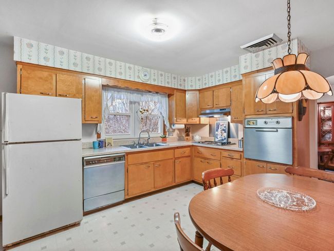 Kitchen featuring gas cooktop, stainless steel dishwasher, sink, white refrigerator, and oven | Image 16