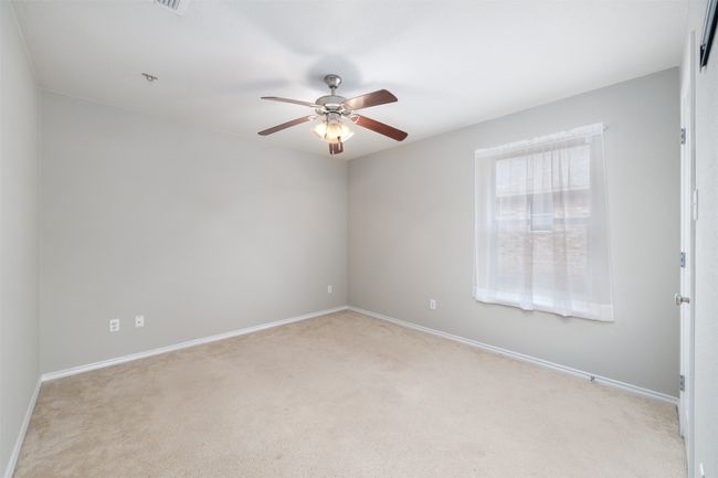 bedroom with light carpet, baseboards, and ceiling fan | Image 17