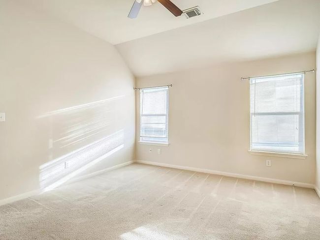 Unfurnished room featuring light carpet, baseboards, a ceiling fan, and lofted ceiling | Image 16