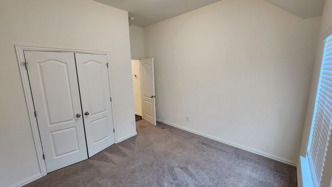 Unfurnished bedroom featuring carpet floors, multiple windows, baseboards, and a closet | Image 15