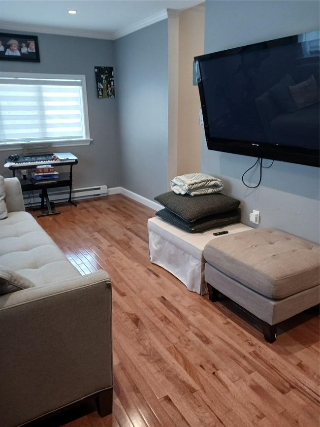 Living room featuring a baseboard heating unit, recessed lighting, baseboards, ornamental molding, and wood finished floors | Image 10