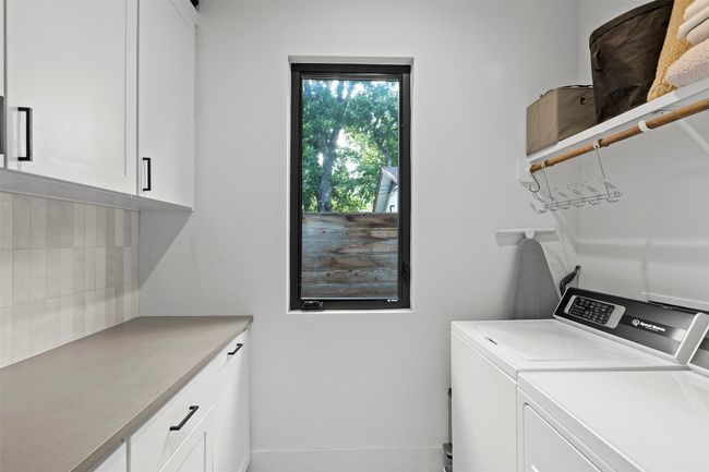Laundry area featuring cabinet space and washing machine and clothes dryer | Image 21