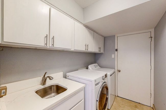 Laundry room with a sink, cabinet space, and washing machine and dryer | Image 23