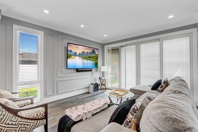 Living area featuring a decorative wall, wood finished floors, crown molding, and recessed lighting | Image 11