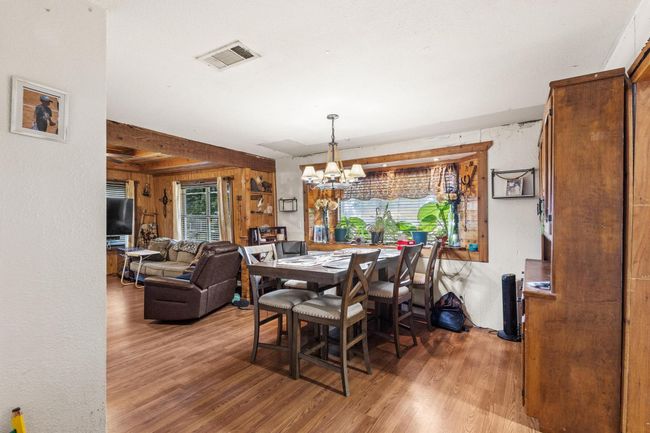 Dining area with wood finished floors and a chandelier | Image 8