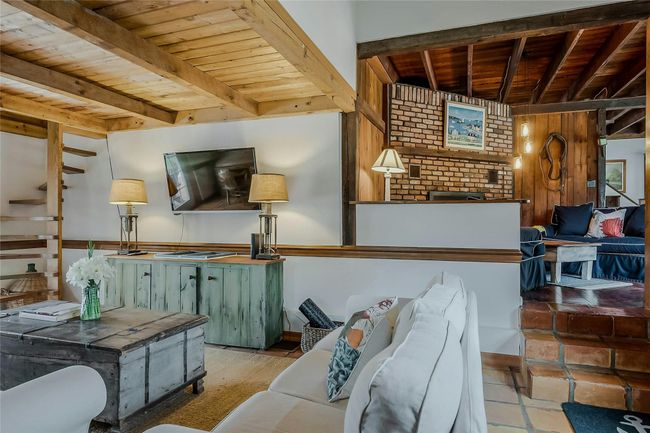 Living area featuring wooden ceiling with exposed beams | Image 7
