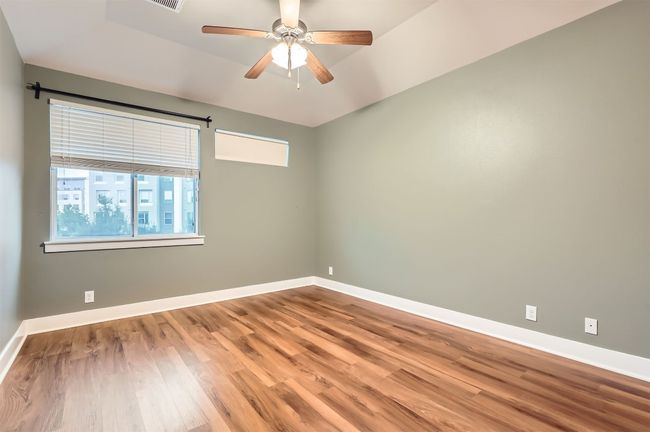 Spare room featuring wood finished floors, a ceiling fan, and lofted ceiling | Image 12