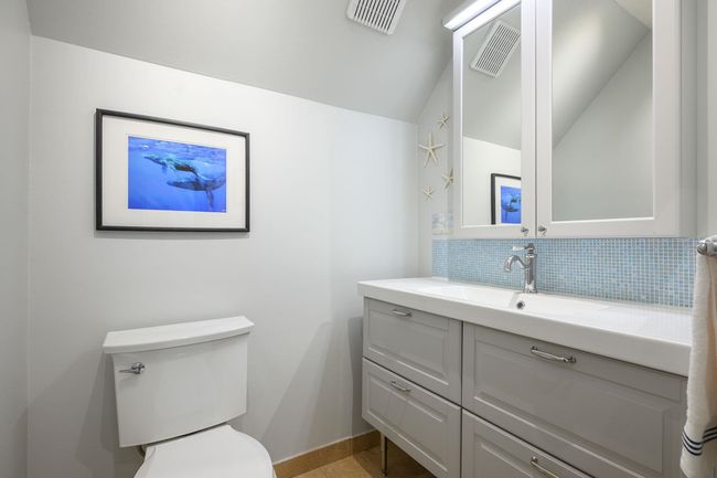 Half bathroom with lofted ceiling, vanity, and backsplash | Image 25