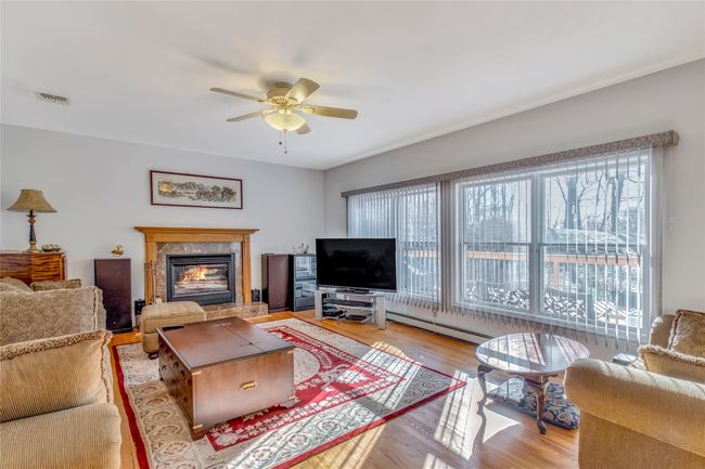 Living room with ceiling fan, light hardwood / wood-style flooring, and a baseboard radiator | Image 6