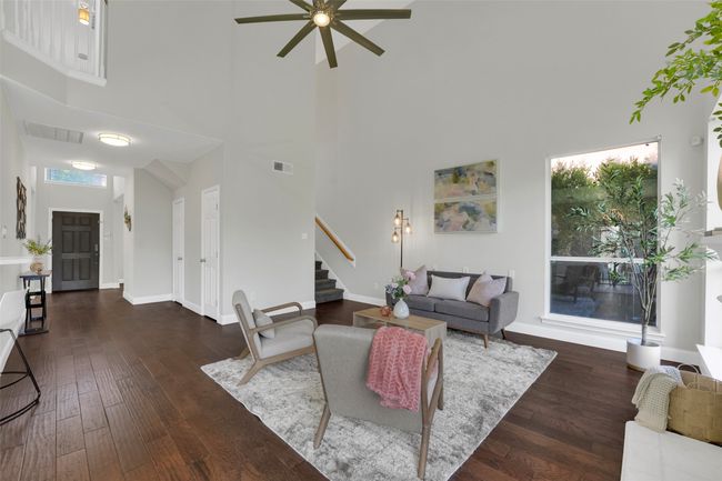 Living area featuring a high ceiling, stairway, ceiling fan, and hardwood / wood-style floors | Image 14