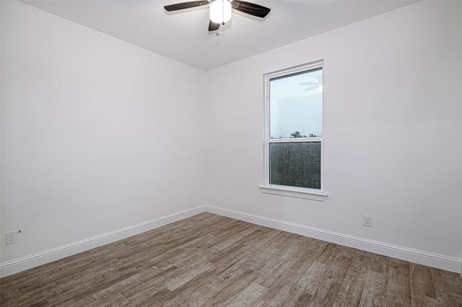 Spare room with wood finished floors, a ceiling fan, and baseboards | Image 17