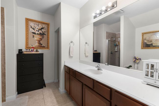 Full bathroom with a stall shower, vanity, baseboards, tile patterned flooring, and visible vents | Image 27