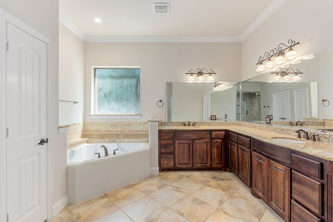 Bathroom featuring visible vents, a garden tub, ornamental molding, and a sink | Image 27