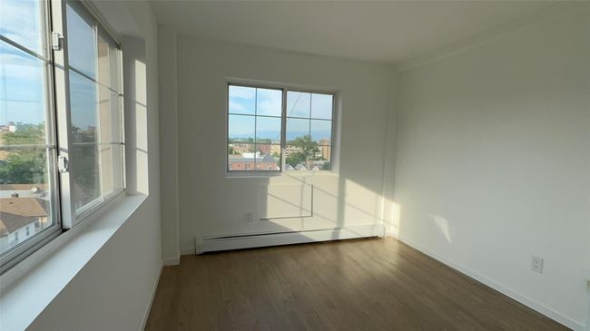 Spare room with a baseboard radiator and wood finished floors | Image 18