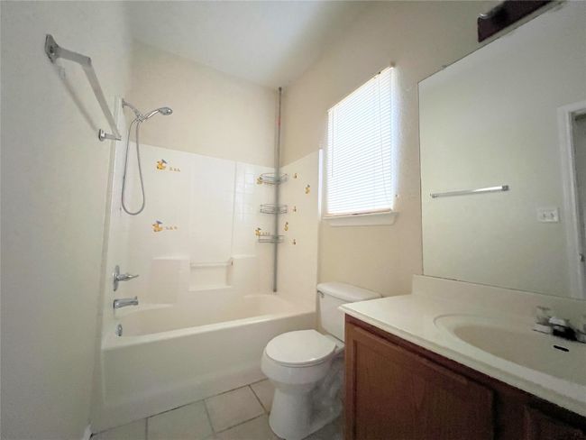 Bathroom with toilet, tile patterned floors, vanity, and bathtub / shower combination | Image 5