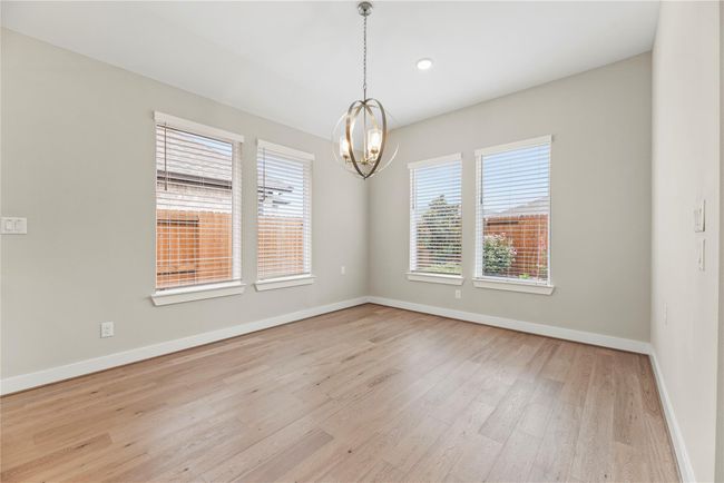 Your friends and family will love breaking bread with you in this elegant dining area, featuring warm LVP flooring, abundant natural light, and a striking modern chandelier that adds a touch of sophistication to every meal. | Image 12