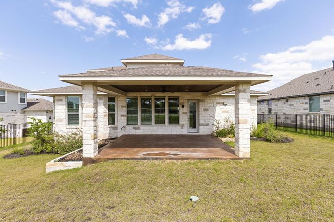 Back of property with a patio, stone siding, roof with shingles, and a ceiling fan | Image 30