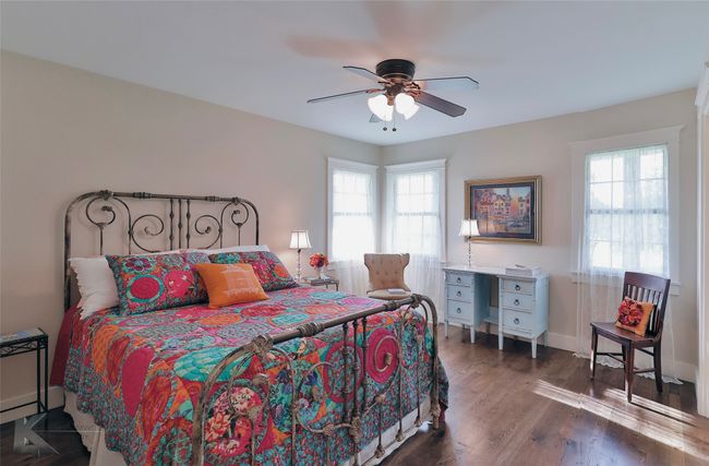 Bedroom featuring multiple windows, wood floors, and ceiling fan | Image 21