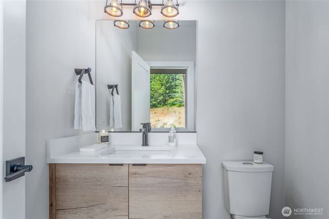 The main floor features a stylish guest half bath with sleek modern cabinetry and designer finishes | Image 28
