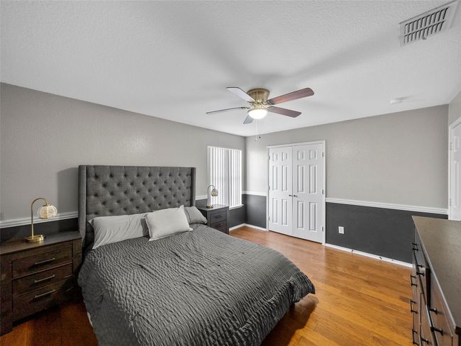 Bedroom with wood finished floors, visible vents, a closet, baseboards, and ceiling fan | Image 27