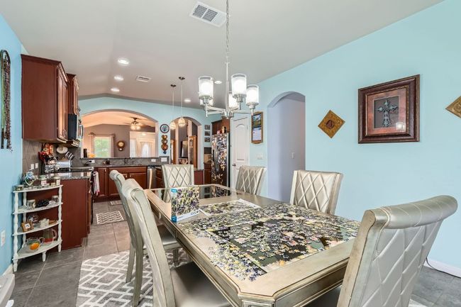 Dining room with recessed lighting, visible vents, arched walkways, and a chandelier | Image 9