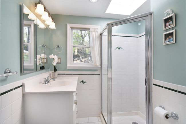 Bathroom featuring vanity, a wainscoted wall, a stall shower, and tile walls | Image 16