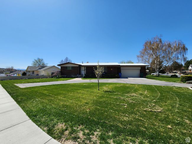 Ranch-style house featuring a garage, a residential view, driveway, and a front yard | Image 58