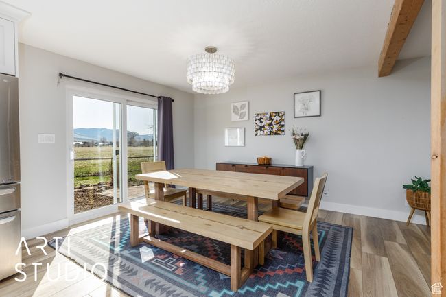 Dining room featuring light wood-type flooring, baseboards, a notable chandelier, and a mountain view | Image 16