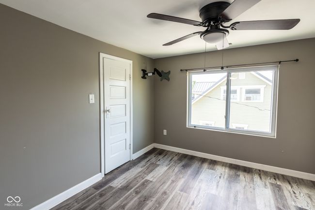 empty room featuring baseboards, a ceiling fan, and dark wood-style flooring | Image 31