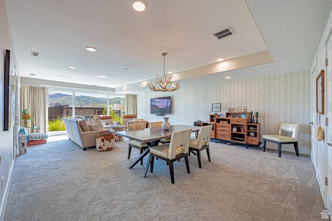 Carpeted dining space with a chandelier and recessed lighting | Image 17